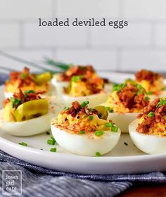 deviled eggs on a white plate with green peppers