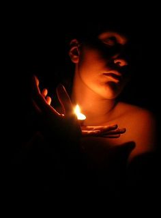 a woman holding a lit candle in her hands