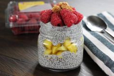 chia pudding with raspberries and pineapples in a jar on a table