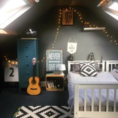 a bed room with a neatly made bed and a guitar on the dresser next to it