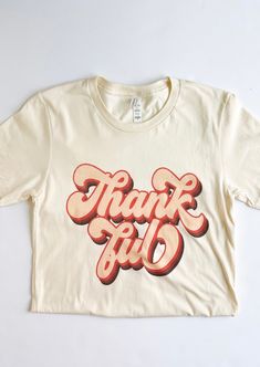 Graphic reads: "Thankful" Cream tee Brown & tan graphics Short sleeves Crew neckline 100% Cotton Soft and comfy Lightly stretching Fit: True to size. Relaxed women's fit SIZE CHART (Measured in inches) Size Fits Like Length Bust Small 2/4 29 36 Medium 6 29.5 38 Large 8/10 30 40 X-Large 12 30.5 42 Model Specs Model is wearing a SMALL. Height: 5'7 Size: 0/2 Cream Graphic Tee, Knitting Materials, Crew Neckline, Graphic Tee, Graphic Tees, Short Sleeves, Size Chart, How To Wear