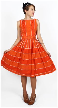 "S T R A I G H T T A L K ▲ Circa: 50s/60s ▲ Tag: Gigi Young ▲ Material: Textured Cotton, Tulle ▲ Condition: Very Good D E T A I L S ▲ Material is a sturdy textured cotton blend ▲ Bright orange, red, & white striped pattern ▲ Sleeveless with square neck ▲ Matching belt ▲ Pleats at waistline ▲ Tulle lining of skirt for extra volume ▲ Bodice is unlined ▲ Covered zipper in back for entry C O N D I T I O N ▲ Very Good Flaws noted: some wear on belt S I Z I N G ▲ Would probably fit a size SMALL be Retro Cotton Dress For Party, Retro Cotton Party Dress, Orange Vintage A-line Dress, Vintage Orange A-line Dress, Retro Vintage Dress Tea Length, Retro Tea-length Lined Vintage Dress, Retro Lined Tea-length Vintage Dress, Vintage Orange Midi Dress For Spring, Vintage Orange Midi Dress For Summer