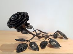 a metal rose sitting on top of a wooden table