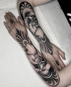 two people with tattoos on their arms and legs, both holding each other's hands