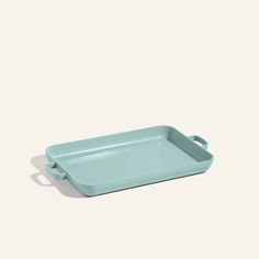 a blue rectangular tray with handles on the bottom and an oval handle at the top