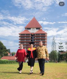 three people standing in front of a tall building