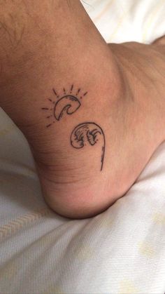 a person with a tattoo on their foot that has the sun and moon above them