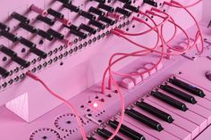 an electronic keyboard with pink strings and black knobs