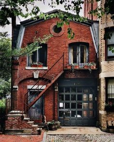 an old brick building with stairs leading up to the front door and second story windows