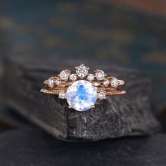 an engagement ring with a blue stone surrounded by white diamonds on top of a rock