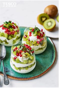 three desserts on a plate with spoons and kiwi fruit in the background