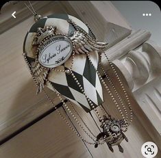 a clock that is hanging from the side of a building with chains attached to it