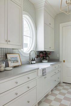 a kitchen with white cabinets and checkered wallpaper on the walls is pictured in this image