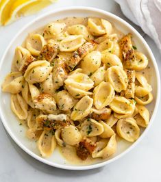 a white bowl filled with pasta covered in sauce