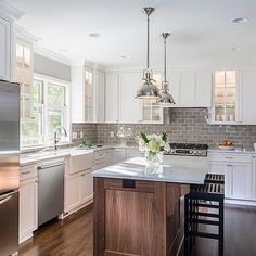 a kitchen with white cabinets and stainless steel appliances