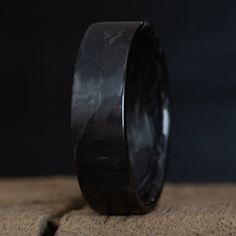 a black ceramic ring sitting on top of a rock