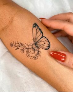 a woman's arm with a butterfly tattoo on it