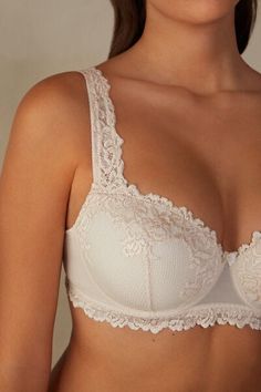 Sofia balconette bra with lightly padded cups and snug underwire that embraces and supports the bust. It is made with an elegant and refined lace available in either two-tone or tone-on-tone options. The underband is lined in tulle to ensure greater hold to the body. The straps are adjustable in back. The underband in larger sizes is wider and a support comes inserted in the cup to better hug and support the bust. It is a design that provides optimal support and emphasizes the décolleté, roundin Balconette Bra With Removable Pads, Elegant Bra With Removable Cups And Underwire, Fitted Balconette Bra With Lace Trim, Elegant Underbust Bra With Removable Pads, Elegant Underbust Bra With Padded Cups, Elegant Underbust Padded Bra, Push-up Bra With Padded Cups For Wedding, Delicate Underwire Bra With Padded Cups, Classic Full Cup Bra With Removable Cups