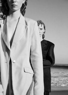 black and white photograph of two women on the beach, one wearing a suit jacket