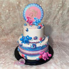 a three tiered cake with blue and pink frosting