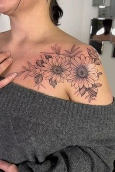 a woman is holding her shoulder with flowers on it