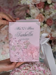 two hands holding a pink wedding album