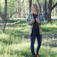 a woman standing in the woods with her hands together