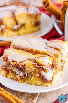 two slices of cinnamon roll cake on a white plate with icing drizzled over them