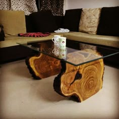 a coffee table made out of wood and glass with a cup on it sitting in front of a couch