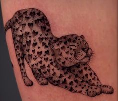 a cheetah tattoo on the back of a woman's leg, with hearts all over it