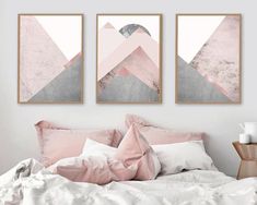 two pink and grey art prints hanging on the wall above a bed in a bedroom