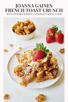 a white plate topped with french toast and strawberries next to a bowl of granola