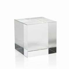 a clear cube shaped object sitting on top of a white surface with no one around it