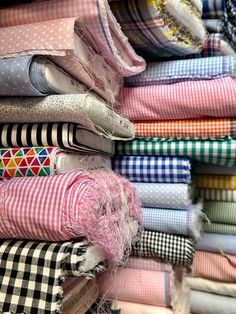 many different colored shirts are stacked on top of each other