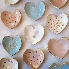 wedding rings are placed in heart shaped dishes on a tablecloth with gold polka dots