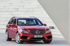 a red mercedes c - class estate wagon parked in front of some stairs and steps