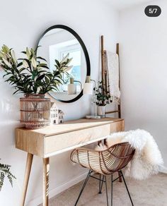 a wooden desk with a mirror and plants on it next to a chair in the corner