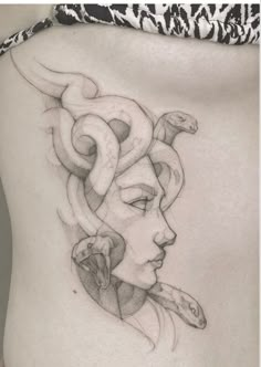 a woman's stomach with an artistic tattoo design on the side and her face