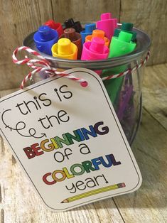 this is the beginning of a colorful year sign in a jar with crayons