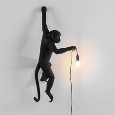 a monkey lamp with a light bulb attached to it's back and its arms in the air