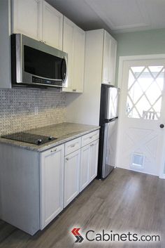 a kitchen with white cabinets and stainless steel appliances