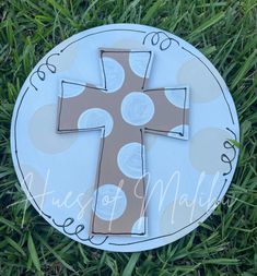 a paper plate with a cross painted on it in the middle of some green grass