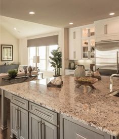 a large kitchen with marble counter tops and stainless steel appliances, along with an island in the middle