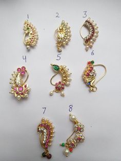 several different types of brooches on a white surface with numbers in the middle