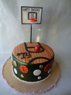 a birthday cake that is decorated with basketballs and a basket on top of it