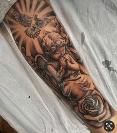 a man with a tattoo on his arm holding a rose and an angel in the sky