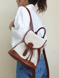 Editor's NotesGONI atelier presents classic accessories that are practical and convenient to use in your daily life. - Leather and canvas combination- Buckle and magnetic closure- Drawstring detail- Open pocket at interior- Classic and casual mood Measurements (in.)One Size- Size: 13.39 in. (W) * 9.84 in. (H) * 7.28 in. (D) - Strap: 29.13 ~ 34.25 in. (H) Composition & Care- Material: Cow Leather (Italy), Linen Cotton Canvas- Natural leather may have fine scratches and wri Casual Canvas Leather-trimmed Backpack, Everyday Canvas Leather Backpack With Leather Trim, Brown Canvas Backpack For Daily Use, Beige Backpack With Leather Trim For Everyday Use, Everyday Leather-trim Canvas Backpack, Everyday Beige Backpack With Leather Trim, Daily Use Brown Canvas Backpack, Everyday Brown Leather Backpack With Canvas Lining, Brown Leather Backpack With Canvas Lining For Daily Use