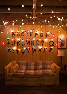 a living room filled with lots of lights next to a wall covered in letters and numbers