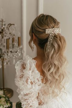 a woman with long blonde hair wearing a white dress and a bow in her hair