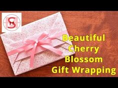 a gift wrapped in pink ribbon with the words beautiful cherry blossom on it's side